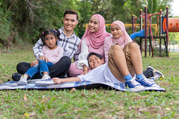 Fototapeta premium young parent with 3 kids at the park