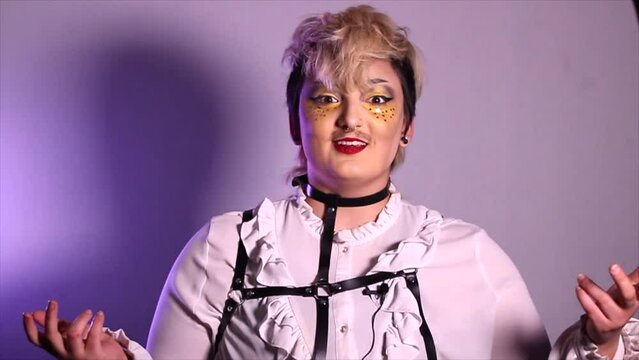 Drag King James Capone in a white frilly shirt and leather chest harness on a purple backdrop. Multiple clips different facial expressions hand gestures body language posing compilation