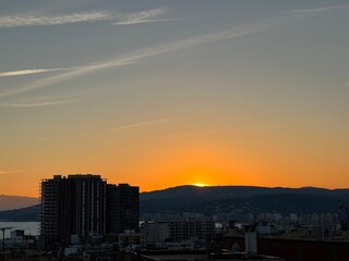 Fototapeta premium Impresionante salida del sol en ambiente urbano y montaña.
