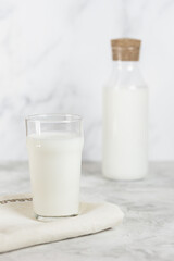 A glass and a bottle of kefir on a concrete table. Healthy nutrition. Selective focus.