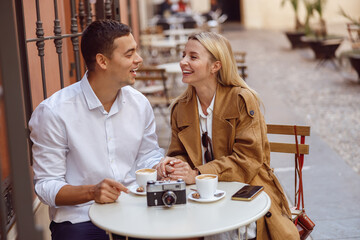 Couple laughing while sitting at cafe table during date