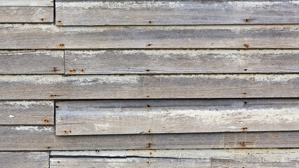 Background of damaged and weathered wooden plank siding