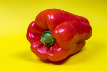 Red bell pepper isolated on yellow background