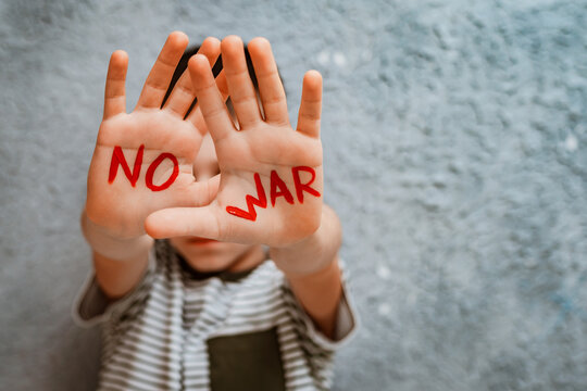 slogan of peace without war is written on the child's hand in red no war.
