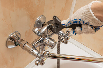 hand holds a wrench that tightens the nut on the tap