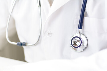 Close up of a stethoscope on a doctor's white lab coat.
