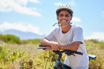 Living life in the fast lane. Shot of a young man sitting on his bike in nature.