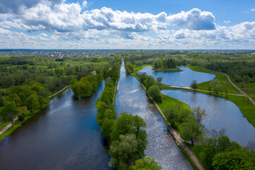 Fototapeta premium A panoramic view from a height of the ponds and the Landscape Park in Peterhof, the meadow garden, walking paths, the destroyed pavilion.