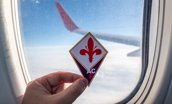 December 6, 2021. Florence, Italy. The emblem of the football club ACF Fiorentina on the background of the airplane window.
