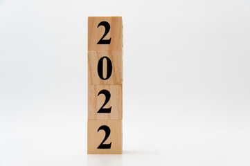 2022 written on wooden blocks in vertical direction isolated on white background with copy space