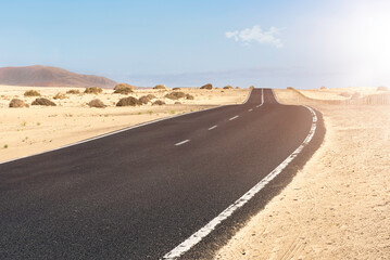 desert road that crosses the dunes of the Corralejo dune natural park in Fuerteventura in Spain.