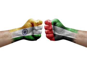 Two hands punch to each others on white background. Country flags painted fists, conflict crisis concept between india and united arab emirates