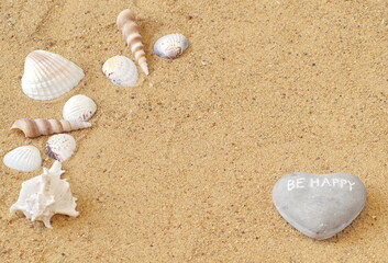 Fototapeta na wymiar On the dog are different types of shells and a stone in the shape of a heart, which says Be Happy. There is a place for your notes - copyspace.