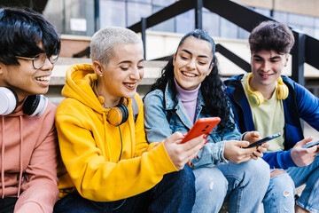 Group of multiracial teenage students using mobile phones on school - Young friends watching social media content on smartphones - obrazy, fototapety, plakaty