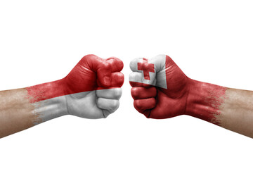 Two hands punch to each others on white background. Country flags painted fists, conflict crisis concept between indonesia and tonga