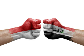 Two hands punch to each others on white background. Country flags painted fists, conflict crisis concept between indonesia and iraq