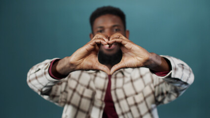 A handsome african man is showing a heart from his hands