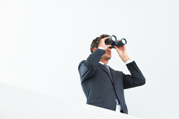 Visionary business man. Low angle view of handsome business man looking through binoculars.