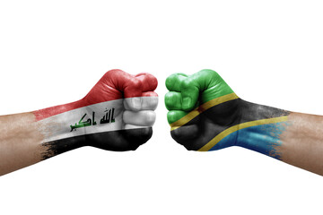 Two hands punch to each others on white background. Country flags painted fists, conflict crisis concept between iraq and tanzania