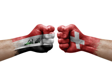 Two hands punch to each others on white background. Country flags painted fists, conflict crisis concept between iraq and switzerland