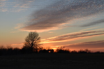 Obraz na płótnie Canvas Dramatic Sunset Over a Rural Field