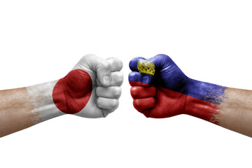 Two hands punch to each others on white background. Country flags painted fists, conflict crisis concept between japan and liechtenstein