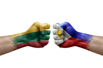 Two hands punch to each others on white background. Country flags painted fists, conflict crisis concept between lithuania and philippines