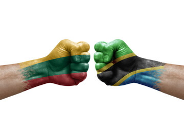 Two hands punch to each others on white background. Country flags painted fists, conflict crisis concept between lithuania and tanzania