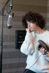 A young curly hair singer woman is worried in the recording studio