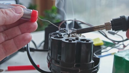 Caucasian Male Electrical Engineer Technician Soldering Wires to Fix Broken Household Appliance...