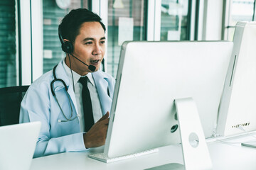 Doctor wearing headset talking actively on video call in a clinic or hospital . Concept of...