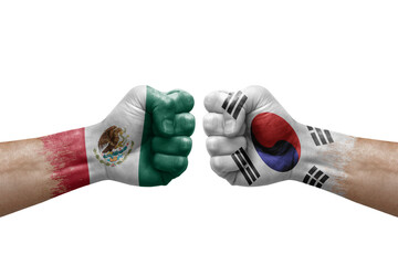 Two hands punch to each others on white background. Country flags painted fists, conflict crisis concept between mexico and south korea