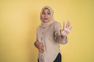 Asian woman in hijab standing with hand gesture refusing offer