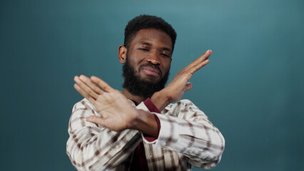 A young black man is gesturing and looking at the camera - obrazy, fototapety, plakaty