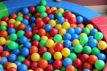 Fototapeta na wymiar Pool of colored balls for children and babies to play and have fun at parties or at home. Concept of diversity, variety, different 
