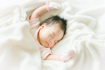 Portrait of Asian newborn or baby girl sleeping on bed New born kid concept.