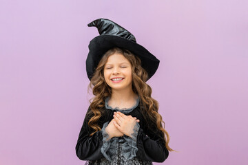 A surprised witch in a magical costume on an isolated background. A joyful sorceress in a magician's hat.