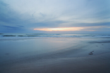 Fototapeta na wymiar Remote natural beauty. A sunset over a desolate cloudy beach.