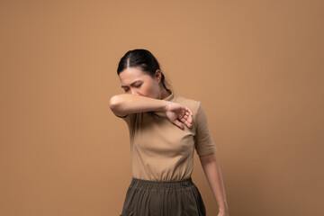 Asian woman was sick with sore throat standing isolated on beige background.
