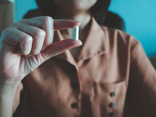 girl's hand holding a round white pill