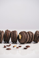 A sweet chocolate macaron French,Chocolate macarons with chocolate ganache filling and mint leaves isolated. French meringue cookies macaron. Top view. Dark background. Copy space.