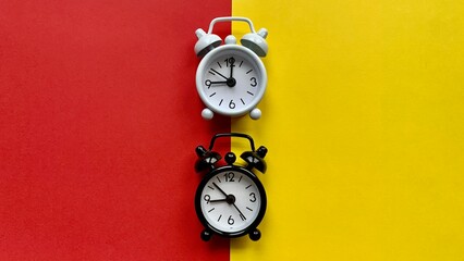 Alarm clocks on red and yellow background. Copy Space