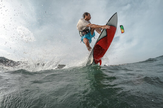 A kite surfer rides the waves.