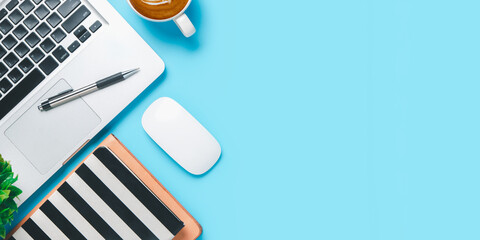 Office desk with computer, Pen, notebook, mouse, Cup of coffee on blue background, Top view with...