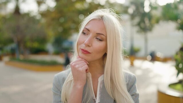 Young blonde woman executive standing with doubt expression at park
