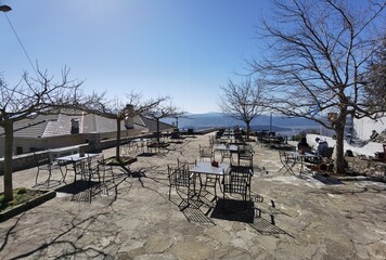 igiades village on the mountain mitsikeli, greek fllag waving old traditional houses in ioannina