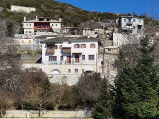 Fototapeta na wymiar igiades village on the mountain mitsikeli, greek fllag waving old traditional houses in ioannina