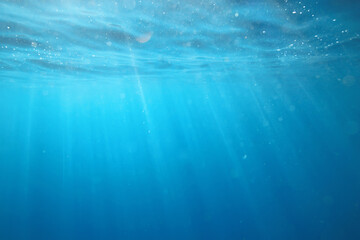 ocean underwater rays of light background, under blue water sunlight