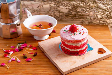 Red velvet cake on wooden plate and tea on wooden table for celebrate in christmas and new year festival.
