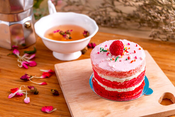 Red velvet cake on wooden plate and tea on wooden table for celebrate in christmas and new year festival.